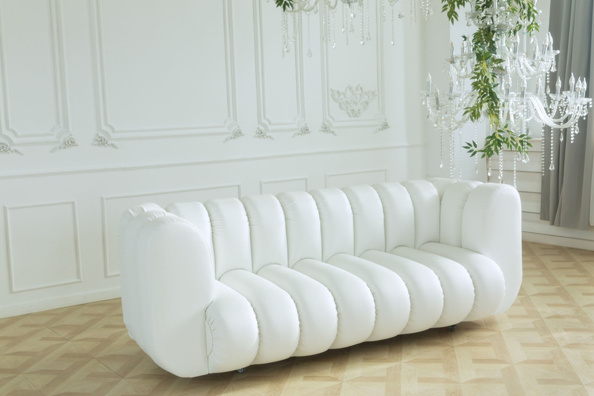 White leather sofa in a bright room against a white wall